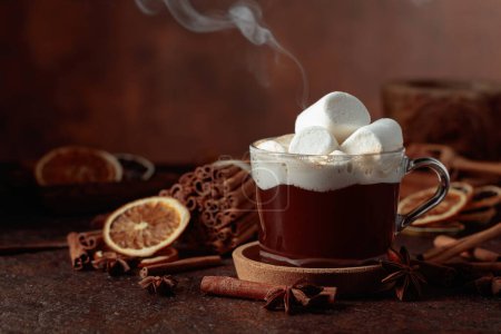 Foto de Chocolate caliente con malvaviscos. Bebida de invierno con especias sobre un fondo marrón oscuro. - Imagen libre de derechos