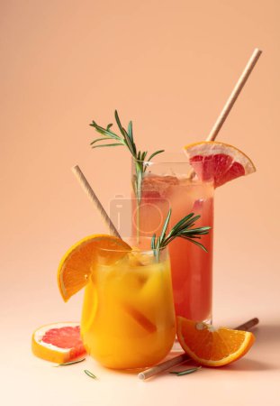 Téléchargez les photos : Orange and grapefruit juice in glasses with rosemary and ice. Copy space. - en image libre de droit