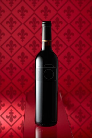 Photo for Bottle of red wine on a red background. - Royalty Free Image