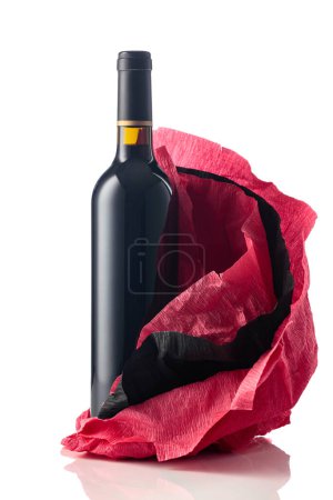 Photo for Bottle of red wine with crumpled red and black crepe paper isolated on a white background. - Royalty Free Image