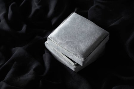 Téléchargez les photos : Coffret cadeau gris sur fond satiné noir. - en image libre de droit