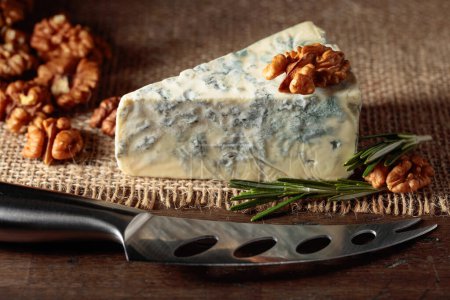 Téléchargez les photos : Fromage bleu aux noix et romarin sur une vieille table en bois. - en image libre de droit