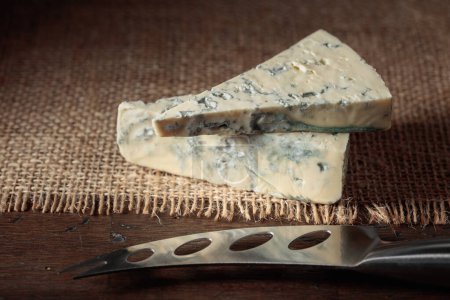 Photo for Blue cheese and cheese knife on an old wooden table. - Royalty Free Image