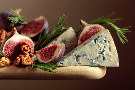 Téléchargez les photos : Fromage bleu aux figues, noix et romarin sur une table en bois. - en image libre de droit