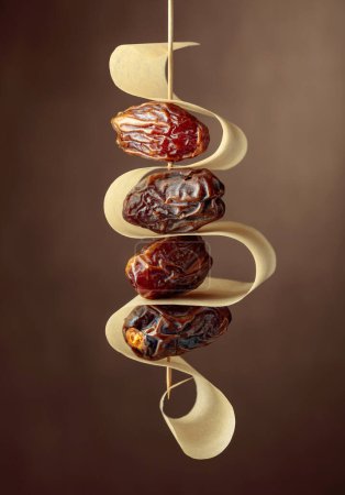 Photo for Dried Arabic dates on a brown background. - Royalty Free Image