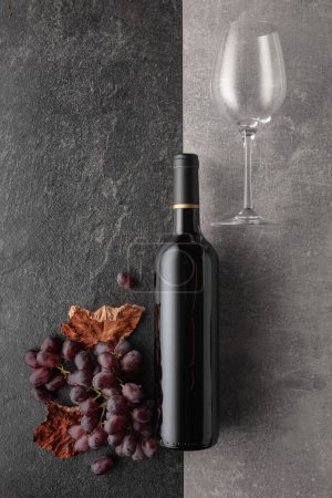 Foto de Vino tinto con uvas sobre un fondo de piedra. Vista superior. - Imagen libre de derechos