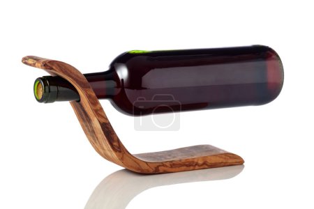 Téléchargez les photos : Bottle of red wine in a wooden bottle holder is isolated on a white background. - en image libre de droit