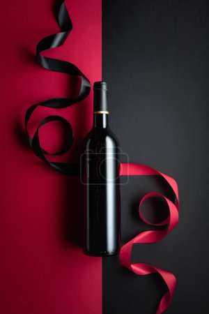 Foto de Bottle of red wine with satin ribbons. Top view. Copy space. - Imagen libre de derechos