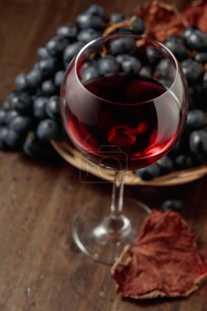 Photo for Red wine and blue grapes on an old wooden table. Selective focus. - Royalty Free Image