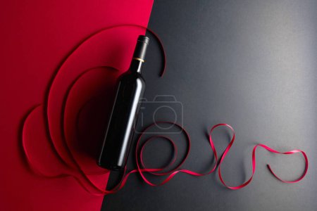 Téléchargez les photos : Bouteille de vin rouge avec rubans de satin rouge. Vue du dessus. - en image libre de droit