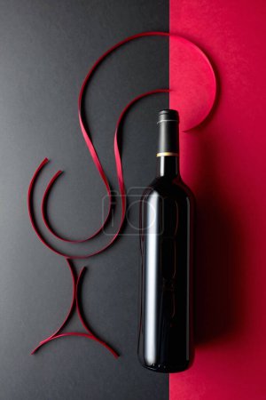 Foto de Botella de vino tinto con cintas de satén rojo. Vista superior. - Imagen libre de derechos