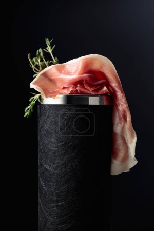 Photo for Prosciutto with thyme on a black background. - Royalty Free Image