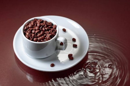 Photo for White cup with coffee beans on a brown background with water ripples. Coffee concept. Copy space. - Royalty Free Image