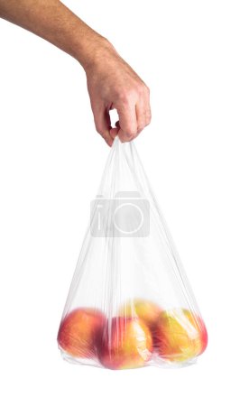 Téléchargez les photos : Main d'homme tenant un sac en plastique avec des pommes rouges. Isolé sur fond blanc. - en image libre de droit