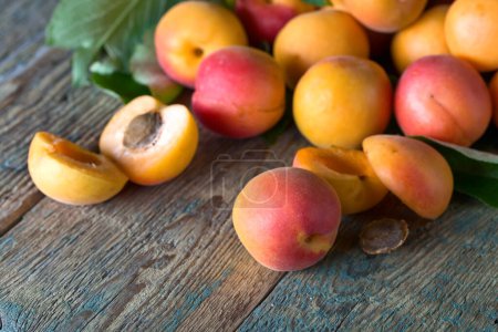 Photo for Juicy fresh apricots with leaves on old wooden table . Natural organic food . - Royalty Free Image
