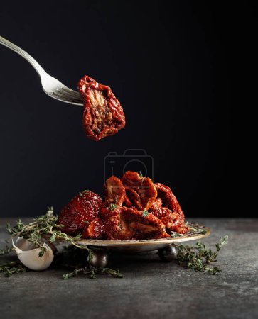 Photo for Sun-dried tomatoes in olive oil on a stone table. Copy space. - Royalty Free Image