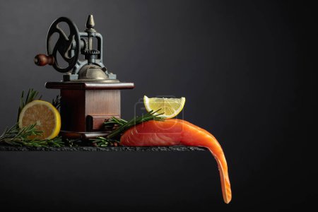 Téléchargez les photos : Salmon with rosemary, lemon, and peppercorn on a dark background. Copy space. - en image libre de droit