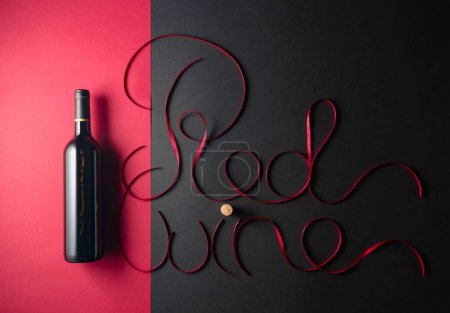 Foto de Botella de vino tinto con cintas de satén rojo. Vista superior. - Imagen libre de derechos