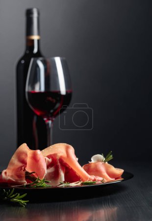 Photo for Italian prosciutto or Spanish jamon with rosemary and red wine. - Royalty Free Image