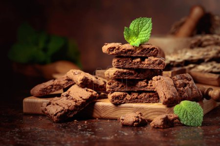 Téléchargez les photos : Pieces of fresh brownie with mint on an old table with kitchen utensils. - en image libre de droit
