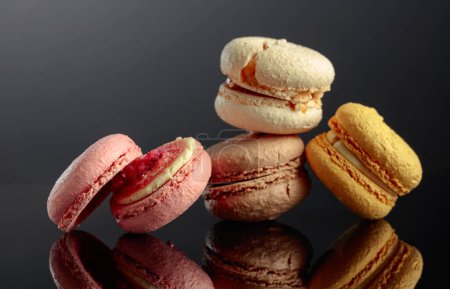 Photo for Delicious sweet colorful macaroons on a black reflective background. Copy space. - Royalty Free Image