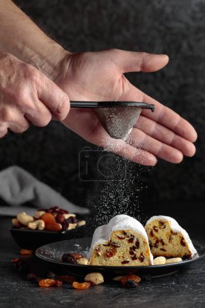 Foto de Pastel de frutas tradicional con pasas y nueces espolvoreadas con azúcar en polvo. - Imagen libre de derechos