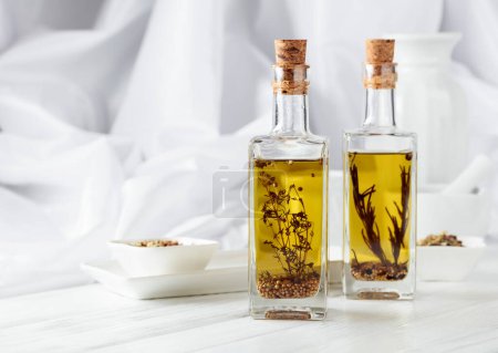 Téléchargez les photos : Bottles of olive oil with spices on a white wooden table. Copy space. - en image libre de droit