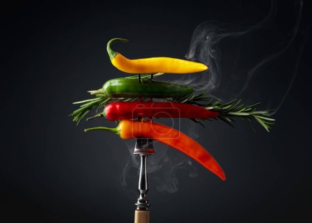 Photo for Hot chili peppers with rosemary on black background. Concept of spicy food. - Royalty Free Image