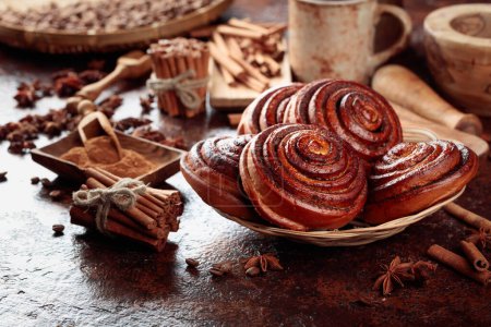 Photo for Freshly baked sweet cinnamon buns with ingredients on a kitchen table. - Royalty Free Image
