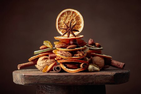 Téléchargez les photos : Nature morte de Noël avec fruits secs, noix et épices sur une vieille table en bois. - en image libre de droit