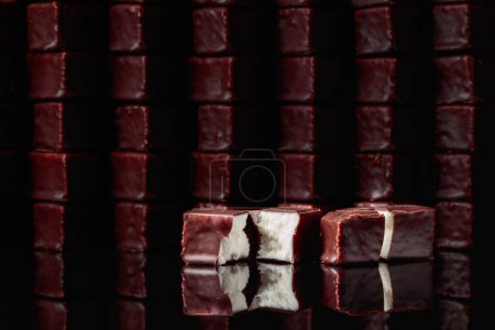 Foto de Dulces de chocolate con soufflé de leche sobre un fondo negro reflectante. - Imagen libre de derechos