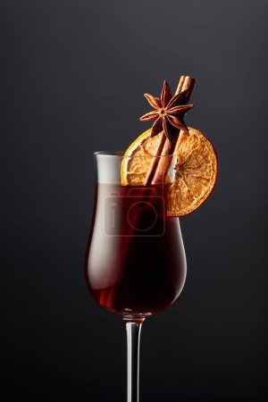 Téléchargez les photos : A glass of liqueur with cinnamon, anise, and a dried orange slice. - en image libre de droit