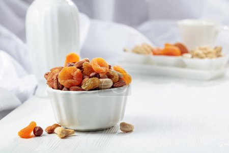 Photo for Dried fruits and assorted nuts on a white wooden table. - Royalty Free Image