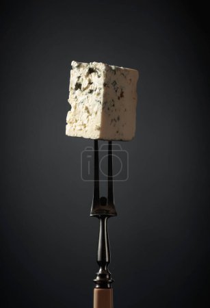 Photo for Blue cheese on a fork. Black background. - Royalty Free Image