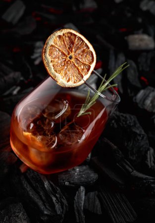 Téléchargez les photos : Cocktail à l'ancienne avec whisky, glace, tranches d'orange séchées et romarin. - en image libre de droit