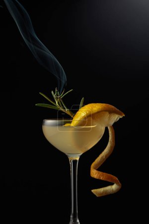 Photo for Limoncello in a glass. A sweet Italian lemon liqueur, a traditional strong alcoholic drink garnished with a steaming rosemary branch. Copy space. - Royalty Free Image