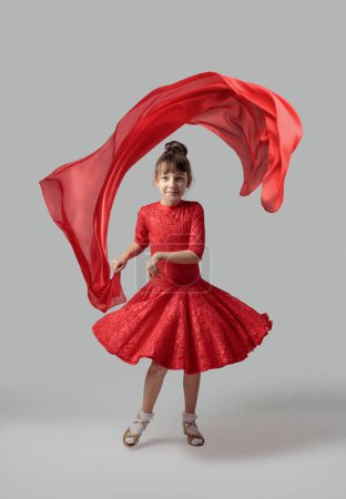 Téléchargez les photos : Fille dansante dans une robe rouge avec volant tissu rouge. - en image libre de droit