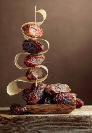 Photo for Dried Arabic dates on an old wooden table. - Royalty Free Image