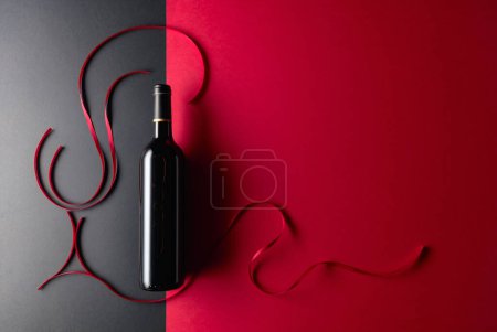 Téléchargez les photos : Bottle of red wine with red satin ribbons. Top view. - en image libre de droit