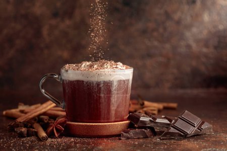 Photo for Hot chocolate with whipped cream sprinkled with chocolate crumbs. Hot chocolate with ingredients on a brown table. - Royalty Free Image