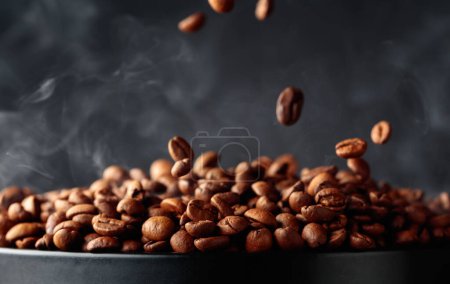 Photo for Steaming coffee beans in movement on a black background. - Royalty Free Image