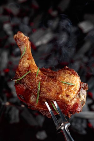 Foto de Grilled juicy chicken with golden-brown crust on a grill with smoke. - Imagen libre de derechos