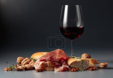 Téléchargez les photos : Prosciutto au vin rouge, baguette, noix et thym. Espace de copie. - en image libre de droit