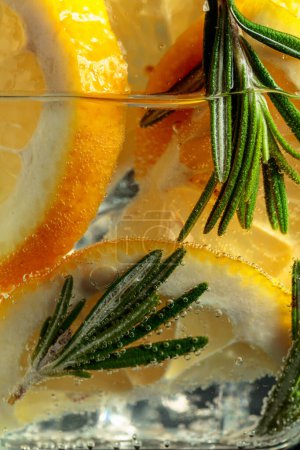 Téléchargez les photos : Boisson gazeuse avec tranches de citron et romarin. Macro shot. - en image libre de droit