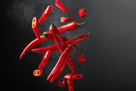 Foto de El pimiento rojo está en movimiento sobre un fondo negro. Tema de comida picante concepto. Copiar espacio. - Imagen libre de derechos