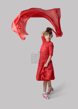 Téléchargez les photos : Fille dansante dans une robe rouge avec volant tissu rouge. - en image libre de droit