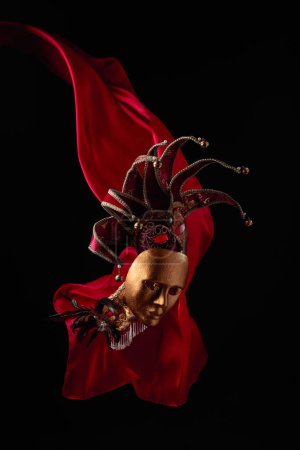 Foto de Máscaras de carnaval viejas sobre un fondo negro con aleteo paño rojo. - Imagen libre de derechos