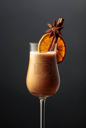 Téléchargez les photos : A glass of Irish cream coffee liqueur with cinnamon, anise, and a dried orange slice. - en image libre de droit