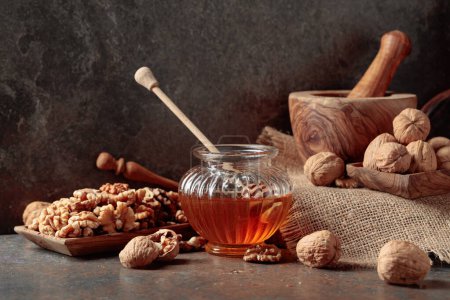 Téléchargez les photos : Miel et noix sur une vieille table de cuisine. - en image libre de droit