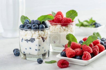 Photo for Dessert with cream, raspberries, and blueberries garnished with fresh mint. - Royalty Free Image